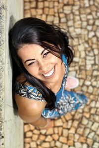 High angle portrait of smiling young woman standing outdoors