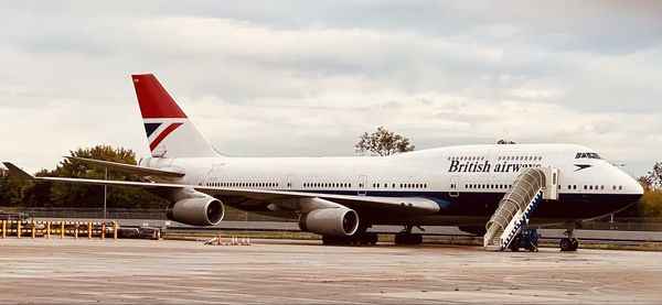 Airplane on airport runway against sky