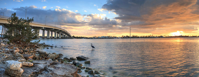 Bridge over river against sky during sunset