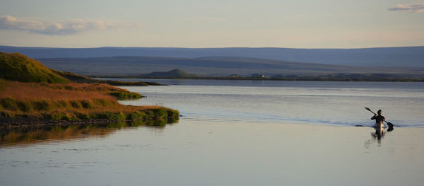 Man enjoying the serenity of lake myvatn on his sea kayak