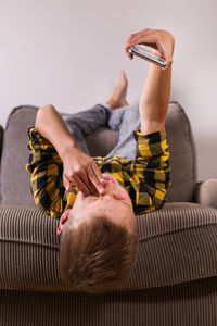 Midsection of man sitting on sofa at home