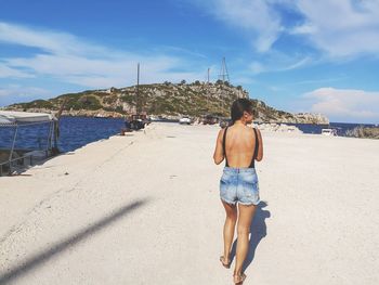 Rear view of woman walking on pier