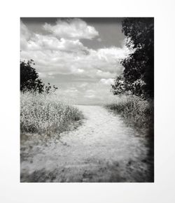 Scenic view of field against cloudy sky