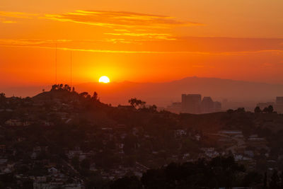 Silhouette buildings against sky during sunset