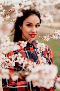 Portrait of beautiful woman by cherry blossom