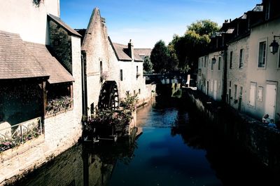 Canal amidst buildings against sky