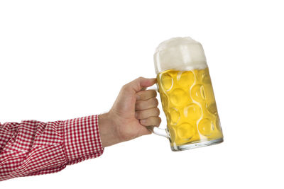 Close-up of hand holding drink against white background
