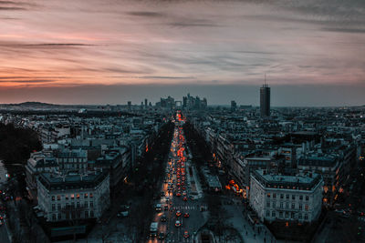 Aerial view of cityscape against cloudy sky during sunset