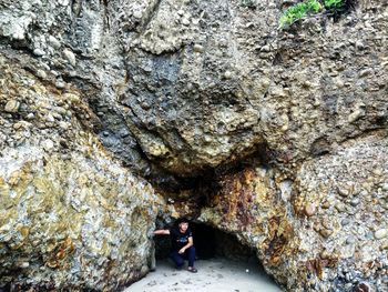 Full length of woman standing on rock in cave