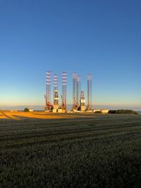 Crane on field against clear sky