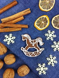 High angle view of gingerbread cookies with lemon and walnuts by cinnamon on table