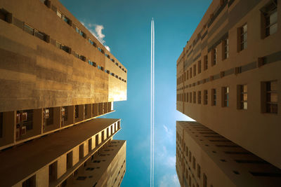 Directly below shot of buildings against blue sky