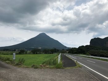 Empty road by mountains against sky
