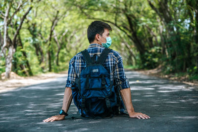Rear view of man standing on footpath in forest