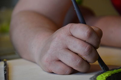 Human hand using paintbrush