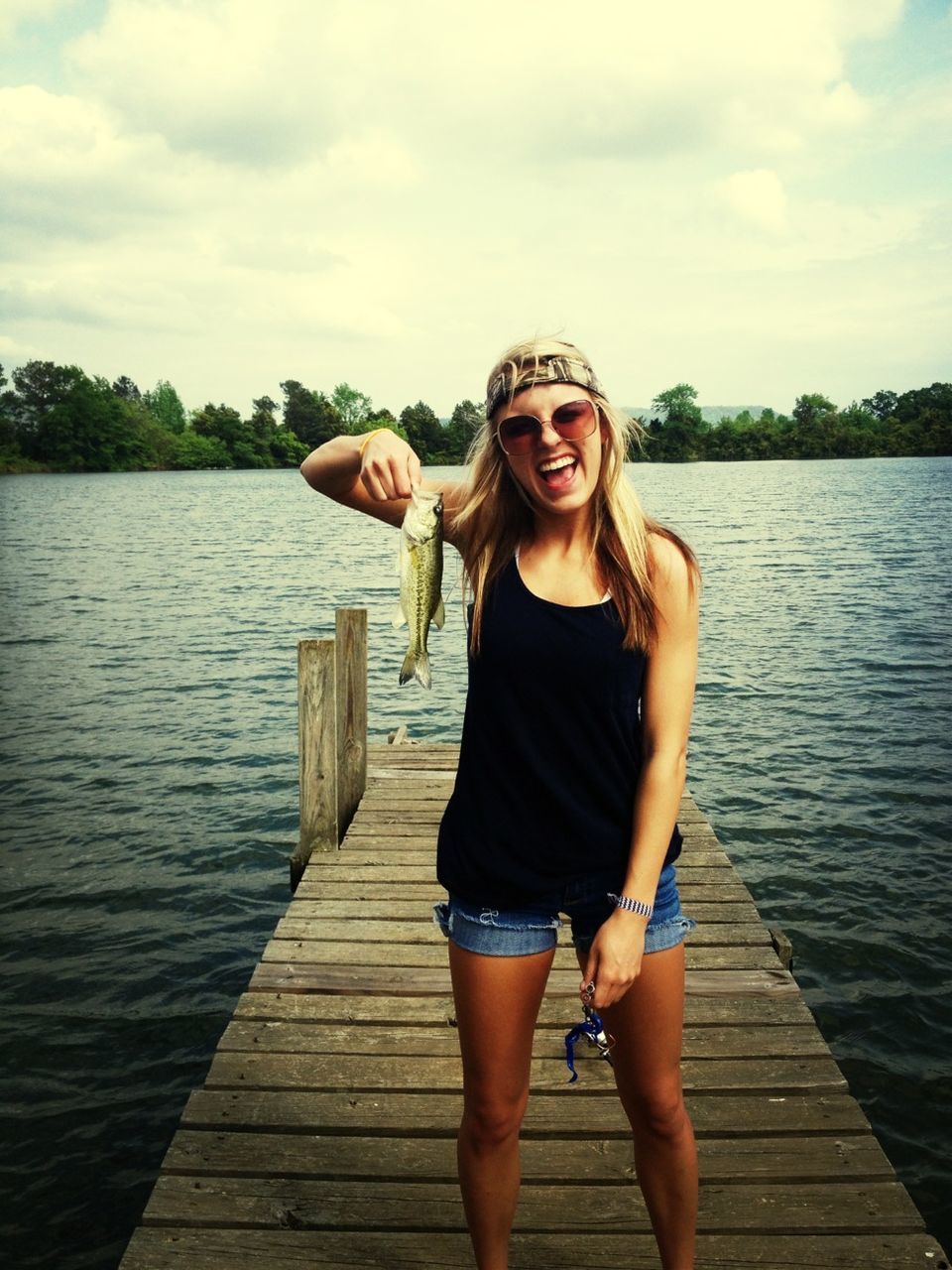 young adult, person, looking at camera, portrait, water, young women, casual clothing, lifestyles, sky, full length, front view, leisure activity, standing, smiling, sunglasses, lake, sitting