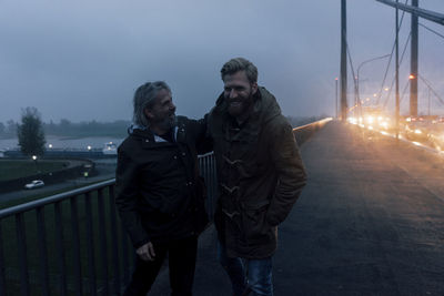 Father and son meeting on bridge, discussing business