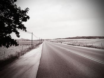 Road amidst trees against sky