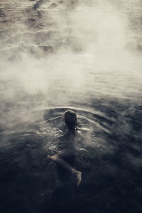 High angle view of woman sitting in water at mammoth lake hot springs