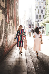 Rear view of women walking on footpath