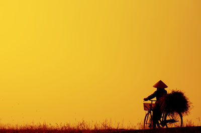 Silhouette person on field against clear sky during sunset