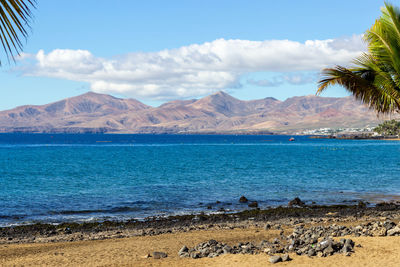 Scenic view of sea and mountains against sky