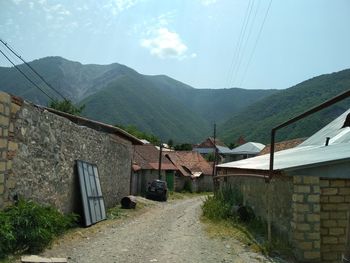 Scenic view of houses and mountains against sky