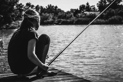 Side view of woman fishing in lake