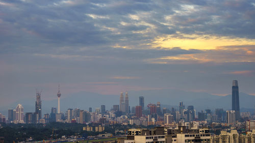 Modern buildings against sky during sunset