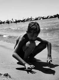 Full length of shirtless boy on beach