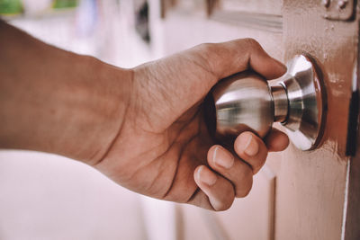 Cropped image of hand opening door