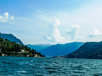 Scenic view of sea and mountains against sky