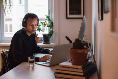 Young freelance worker using laptop at desk