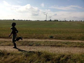 People walking on field against sky