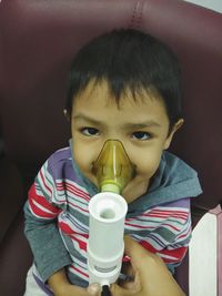 Close-up portrait of cute boy wearing gas mask