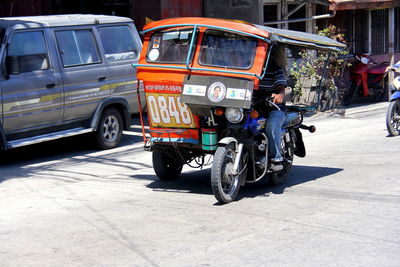 Man driving jinrikisha on city street