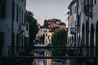 Canal amidst buildings against sky