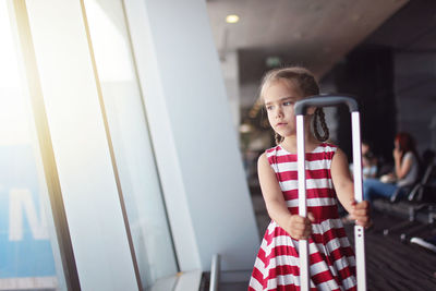 Girl looking away while standing on mirror