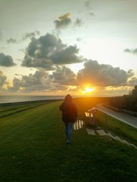 Rear view of a woman walking on field