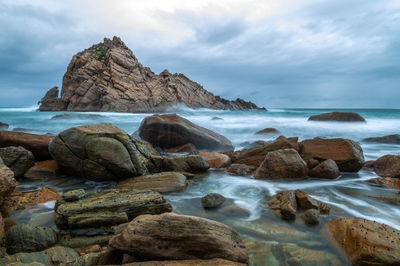 Rocks on beach against sky