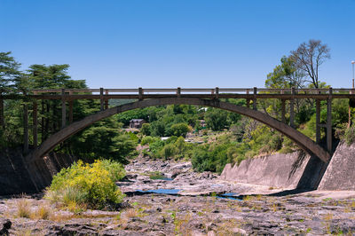 Arch bridge over river against clear sky