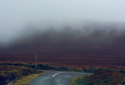 Scenic view of road against sky during foggy weather