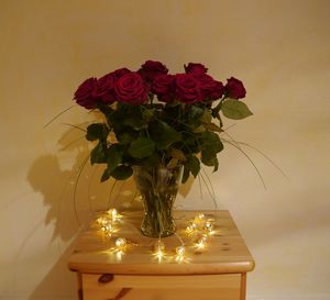 Close-up of vase on table against wall