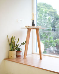 A beautiful wooden table with plant decorations in the corner of the room