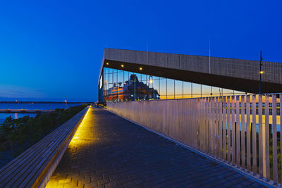 Bridge over sea against clear blue sky