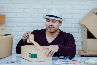 Portrait of young man wearing hat on table