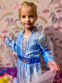 Girl standing against blue wall