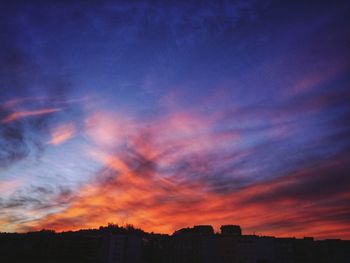 Silhouette cityscape against sky during sunset