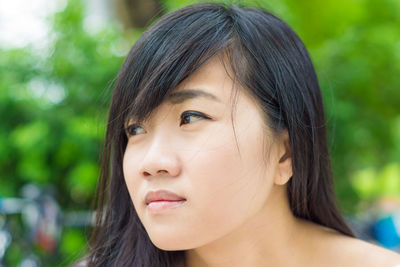 Close-up portrait of young woman looking away
