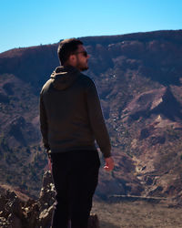 Man standing on rock against mountains